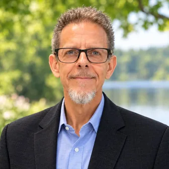 Headshot of Robert J. Veliky, LCSW, smiling outdoors in a dark blazer and light blue shirt.