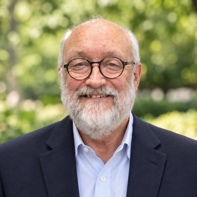 Headshot of Michael R. Harris, M.D., smiling outdoors in a navy blazer and light blue shirt.