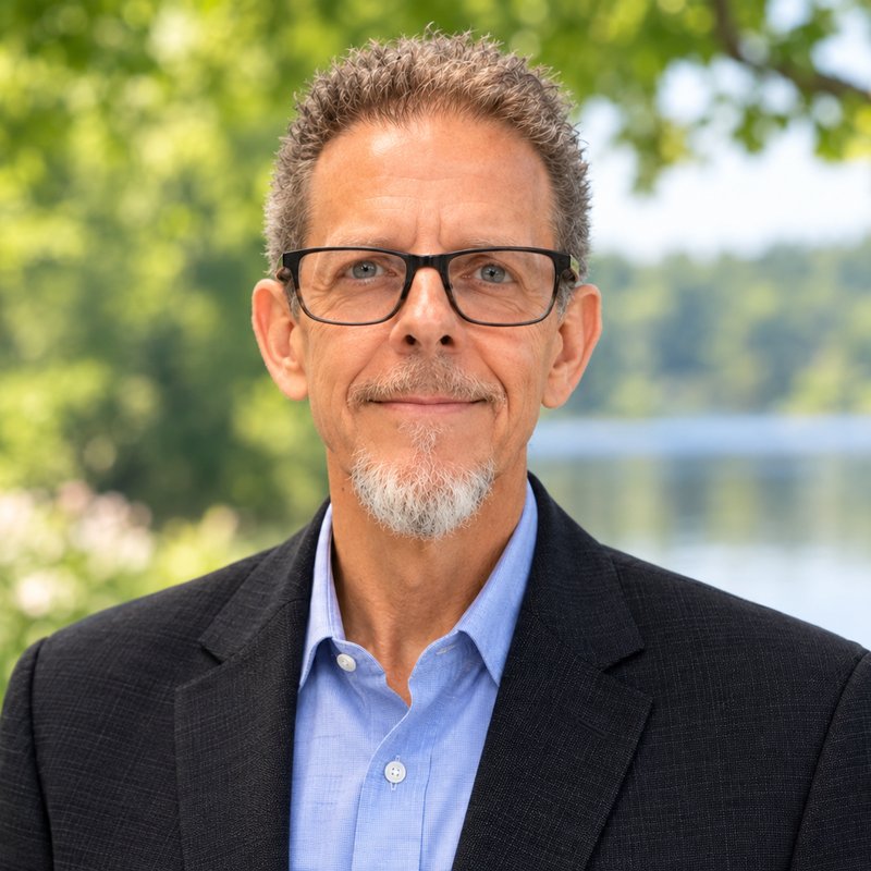 Headshot of Robert J. Veliky, LCSW, smiling outdoors in a dark blazer and light blue shirt.